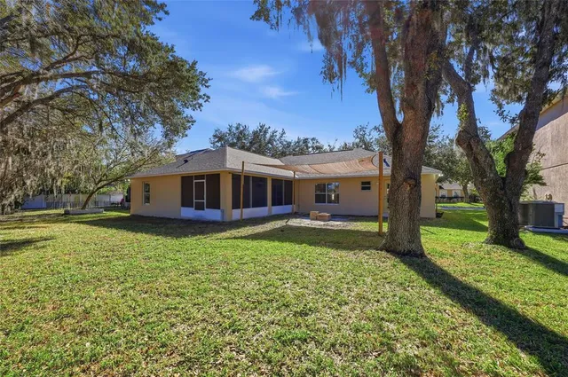 a view of a yard in front of house with a large tree