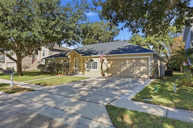 a view of a yard in front of a house with large tree