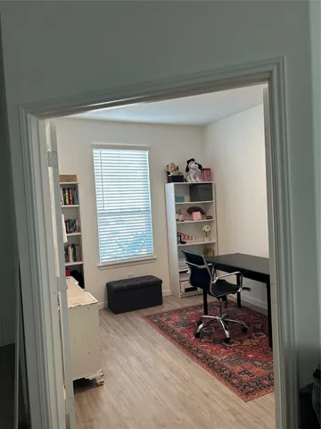 a view of a workspace with furniture and a window