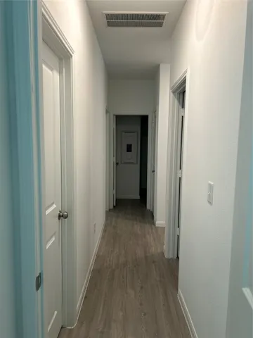 a view of a hallway with wooden floor and closet