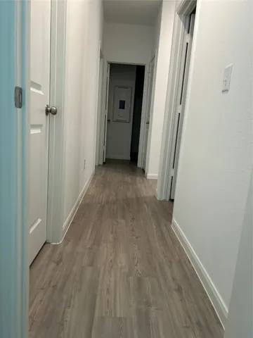 a view of a hallway with wooden floor