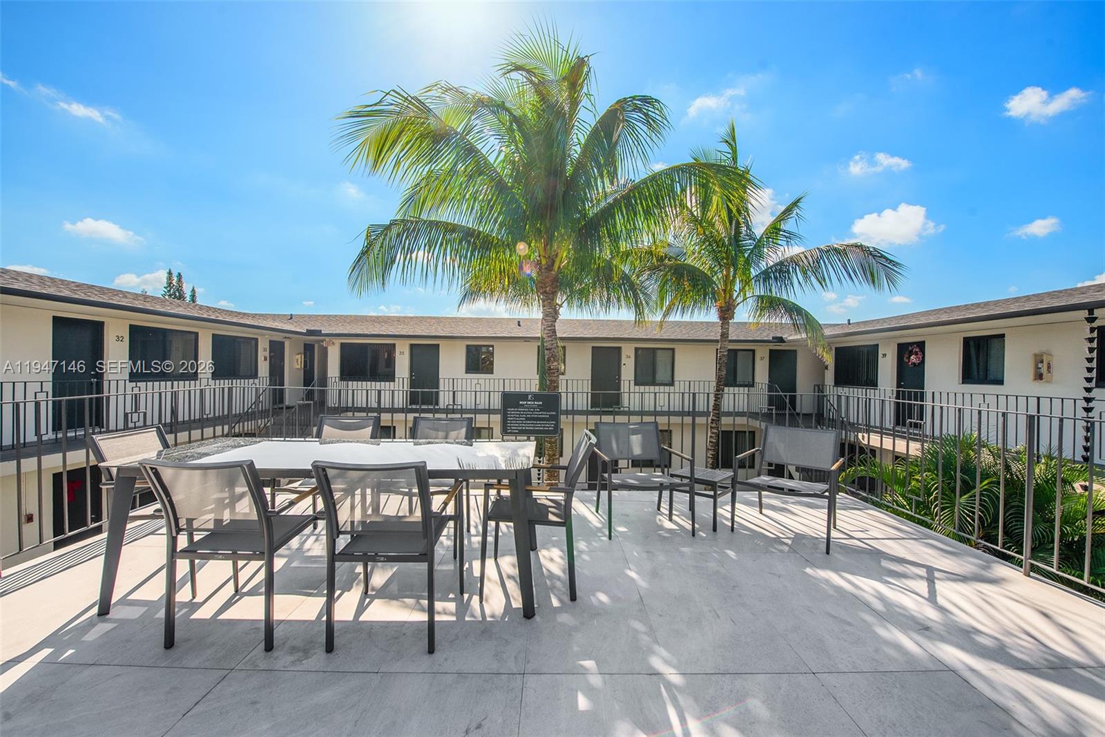 1310 West 29th Street, Unit 28 Hialeah, FL 33012 - Photo 3 of 10 a patio with a table and chairs and potted plants