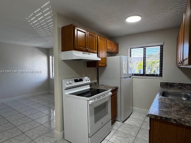 1310 West 29th Street, Unit 28 Hialeah, FL 33012 - Photo 4 of 10 a kitchen with stainless steel appliances granite countertop a stove and a refrigerator