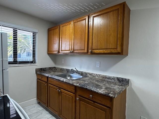 1310 West 29th Street, Unit 28 Hialeah, FL 33012 - Photo 5 of 10 a kitchen with granite countertop cabinets and window