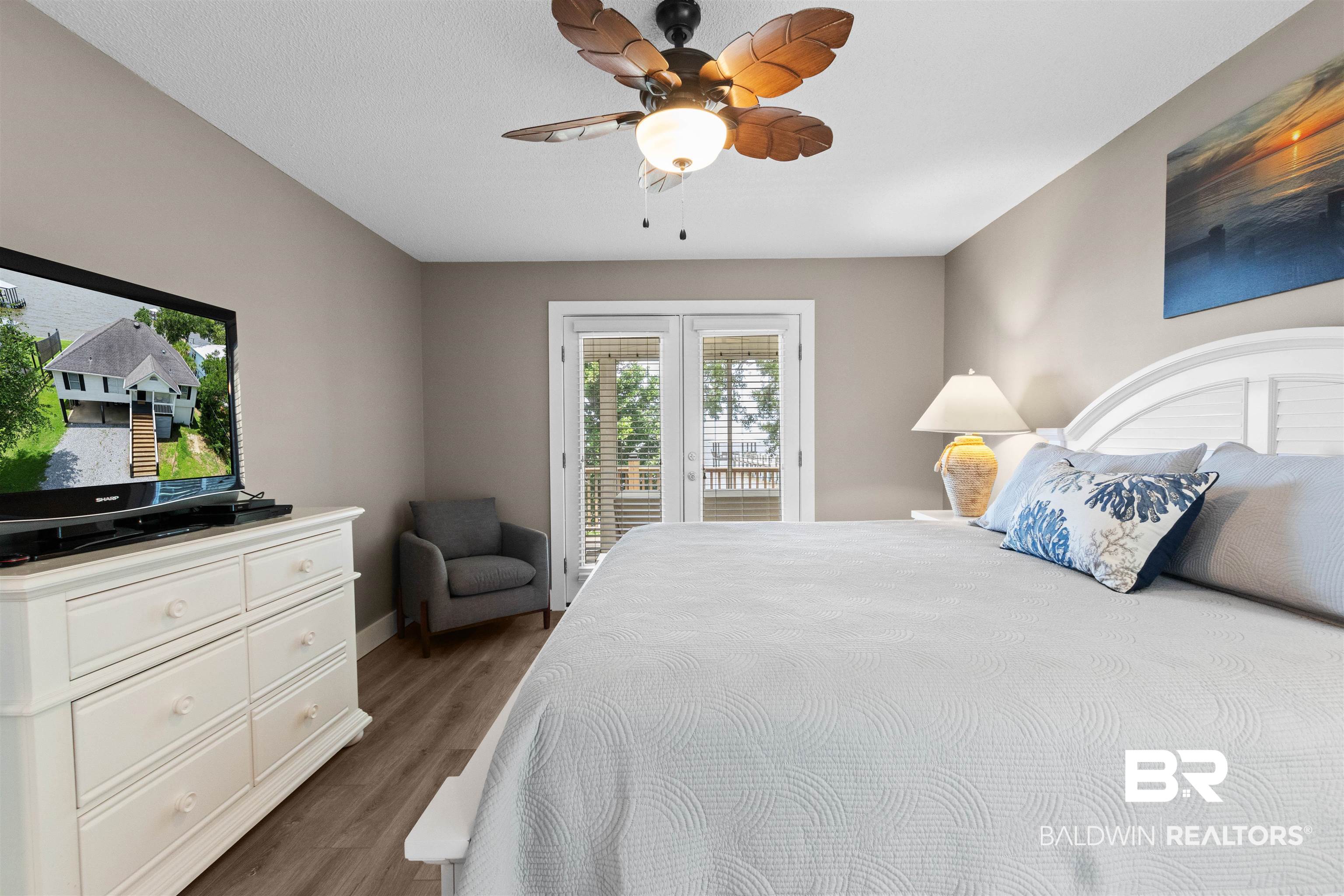 9581 South Bay Street Foley, AL 36535 - Photo 18 of 44 Room featuring French doors, wood-finish flooring, a white paneled headboard, and a tropical-style ceiling fan with integrated lighting
