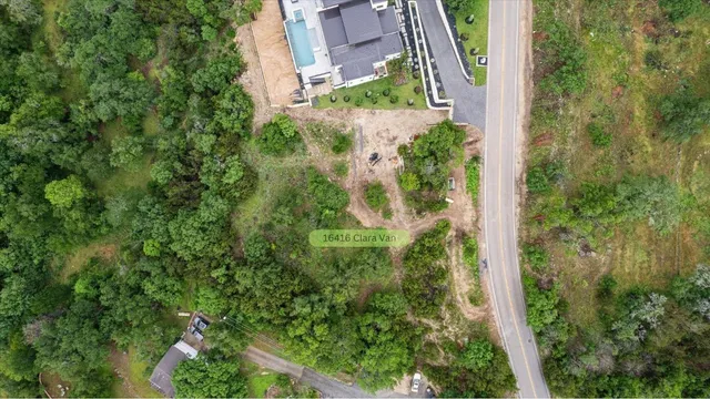 an aerial view of residential house with outdoor space and trees all around