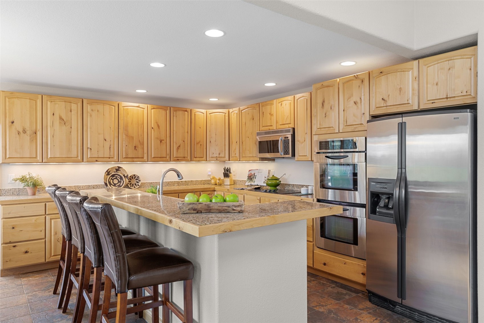 91795 Ryan Gulch Road Silverthorne, CO 80498 - Photo 19 of 50 a kitchen with a refrigerator a stove a sink a dining table and chairs