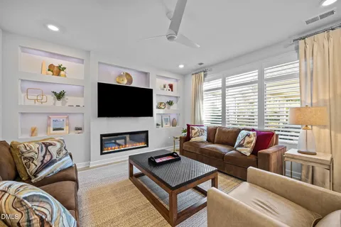 a living room with furniture a flat screen tv and a large window