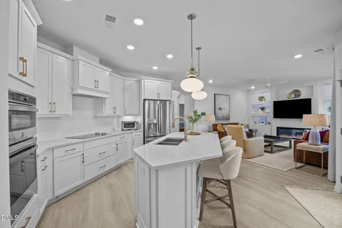 a large kitchen with kitchen island a sink table and chairs