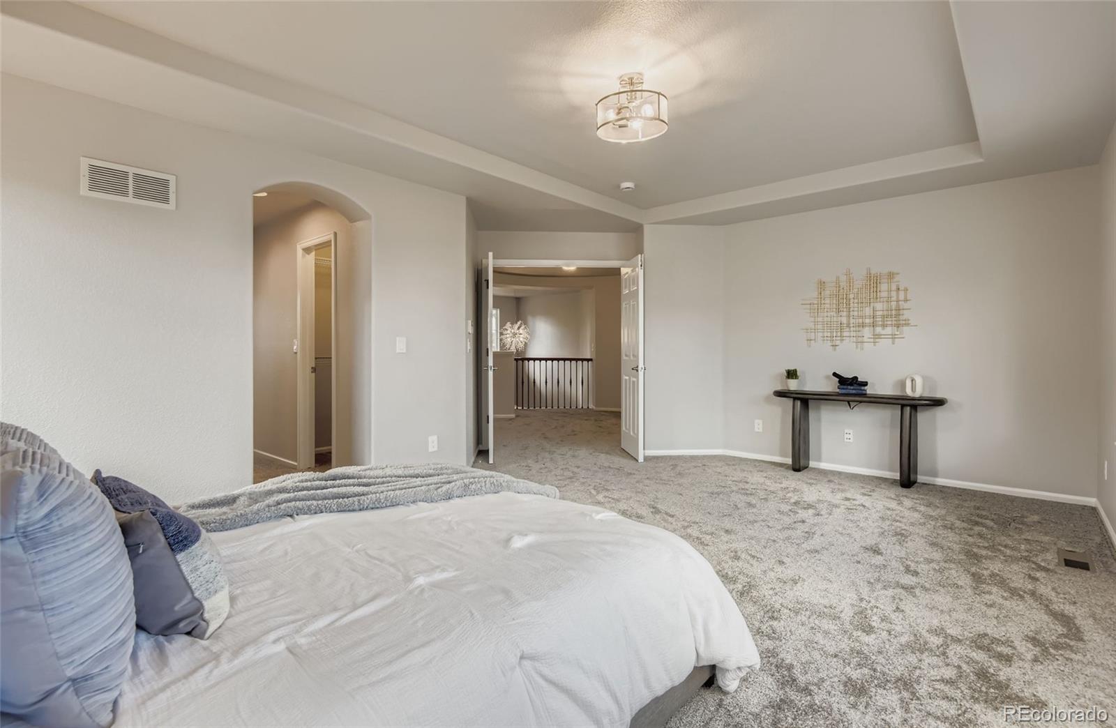 10726 Middlebury Way Highlands Ranch, CO 80126 - Photo 14 of 30 a bedroom with a bed and a chandelier