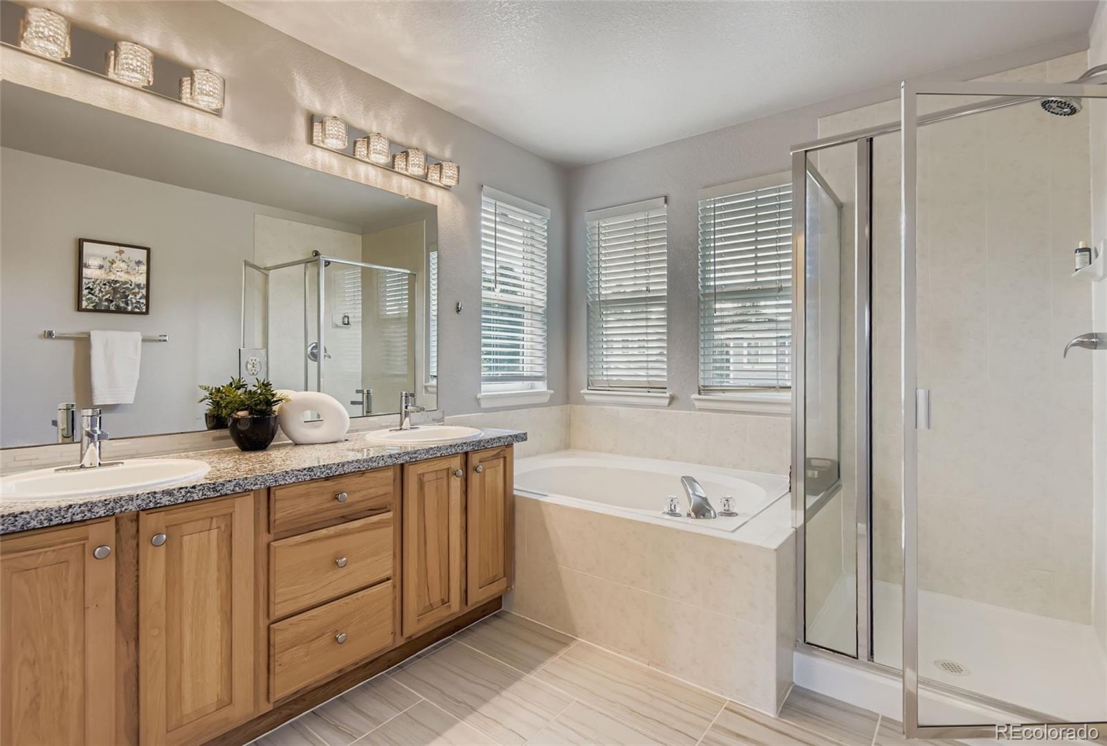 10726 Middlebury Way Highlands Ranch, CO 80126 - Photo 15 of 30 a bathroom with a tub a sink and a mirror