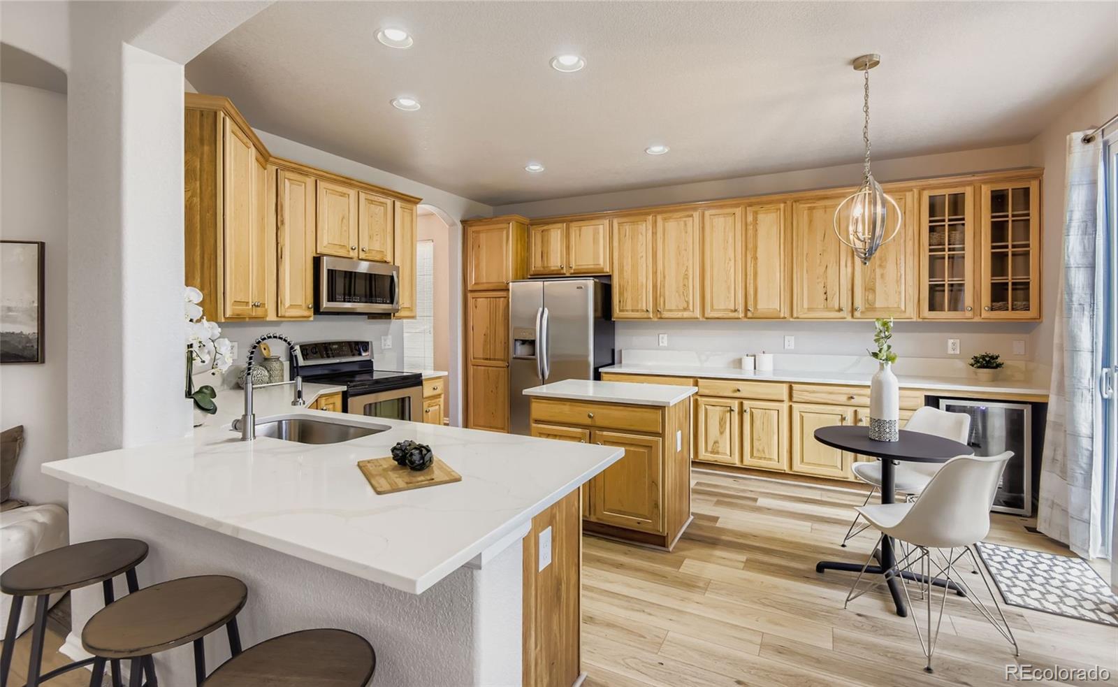 10726 Middlebury Way Highlands Ranch, CO 80126 - Photo 6 of 30 a kitchen with sink a refrigerator and chairs