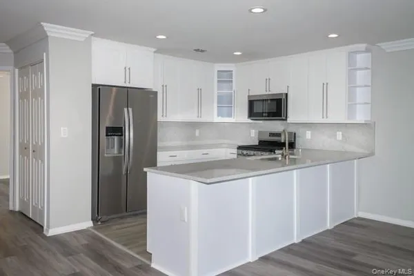 a kitchen with stainless steel appliances granite countertop a refrigerator stove a sink and a microwave