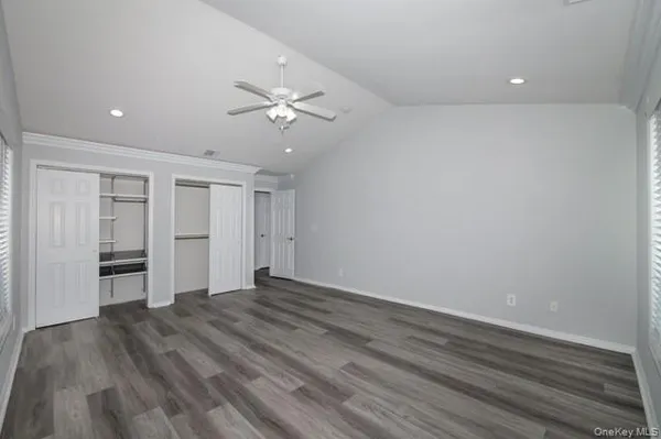a view of empty room with wooden floor and ceiling fan