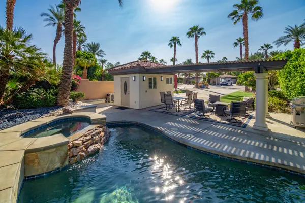 an aerial view of a house with swimming pool a yard and lake view