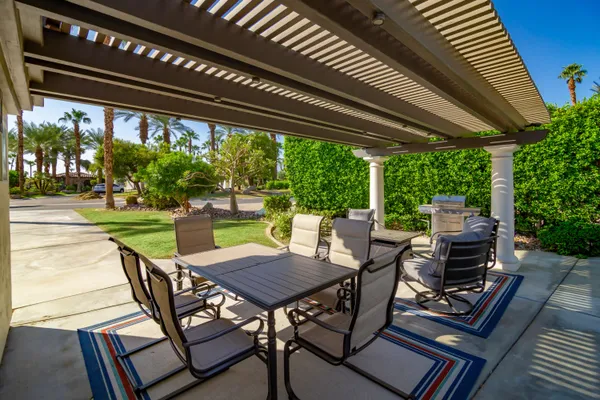 a view of a patio with a table chairs and a backyard