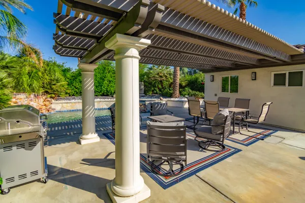 a patio with glass top table and chairs