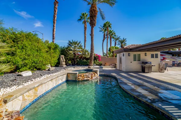 a view of a house with swimming pool and sitting area