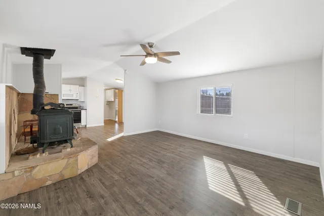 a view of a livingroom with a flat screen tv wooden floor and a ceiling fan