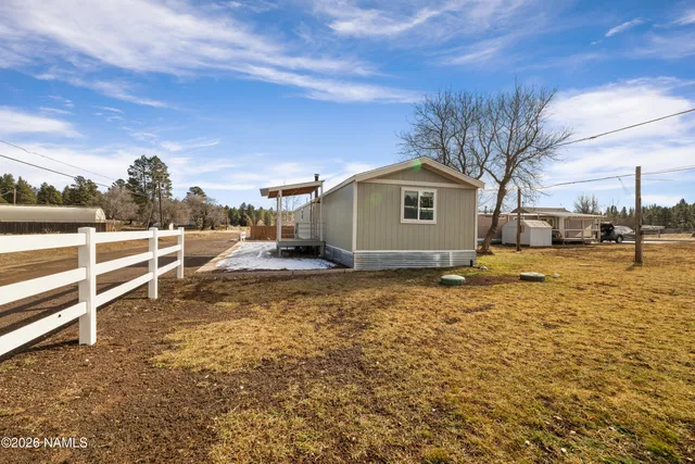 a view of a yard with wooden fence