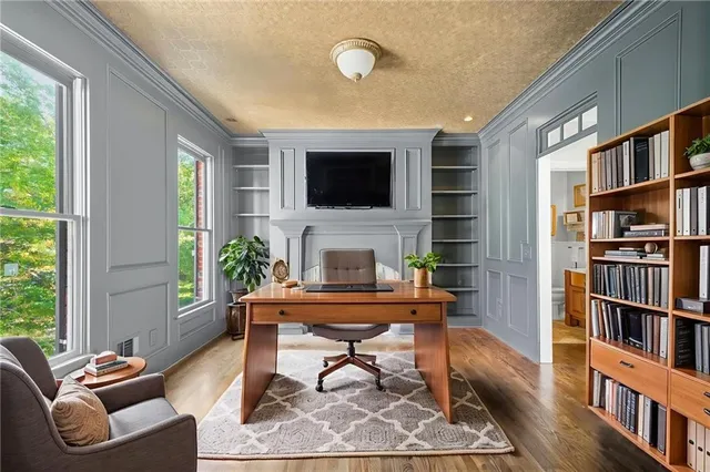 wooden floor fireplace and windows in an empty room