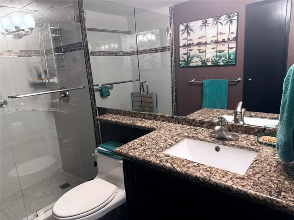a bathroom with a sink a toilet and shower