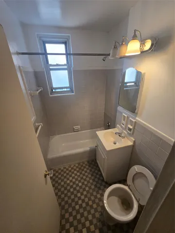a bathroom with a toilet a sink and a mirror
