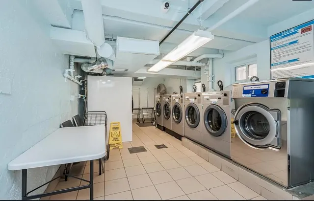 a utility room with dryer washer and stair