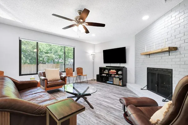a living room with furniture a flat screen tv and a fireplace