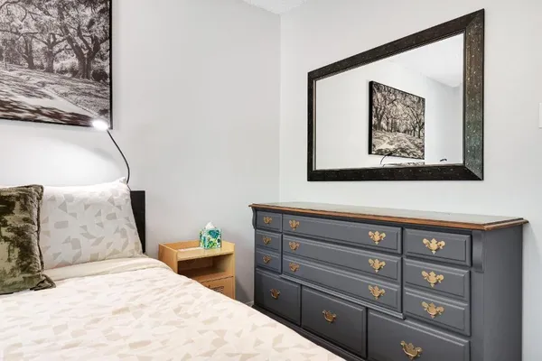 a bedroom with a bed and a painting on the wall