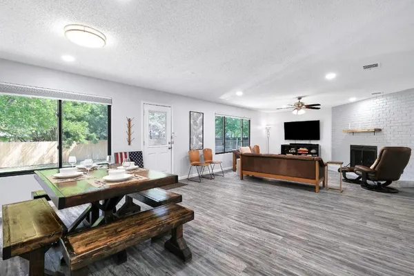 a living room with furniture a flat screen tv and a large window