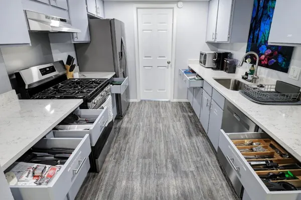 a kitchen with granite countertop a stove and a refrigerator