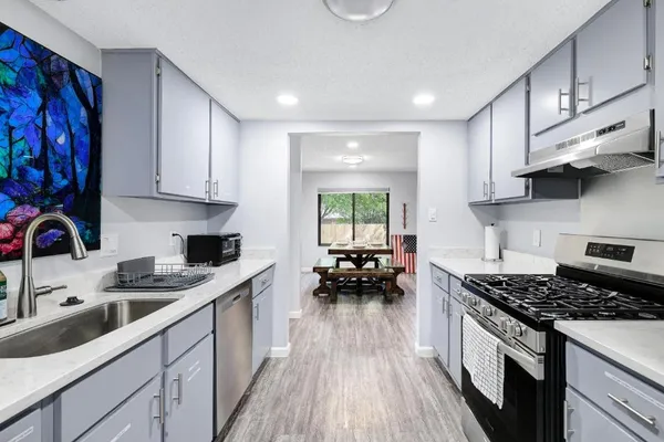 a kitchen with stainless steel appliances a white stove top oven sink and cabinets