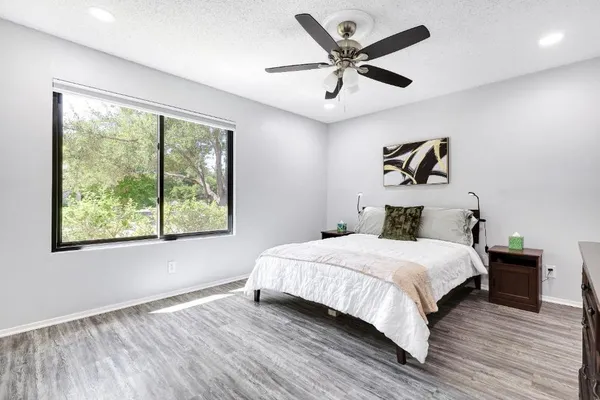 a bedroom with a large bed chandelier and a window