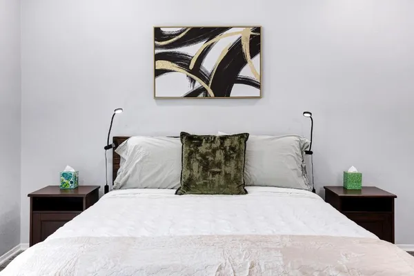 a bedroom with a bed and painting on the wall