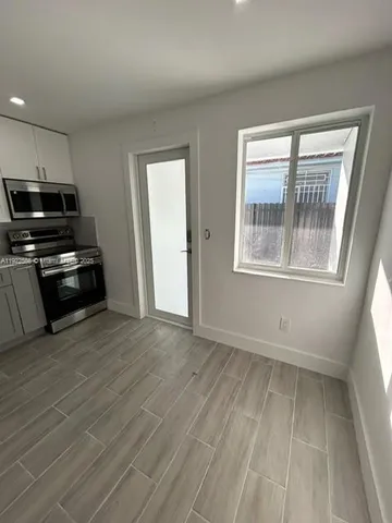 a kitchen with granite countertop a refrigerator and a stove top oven