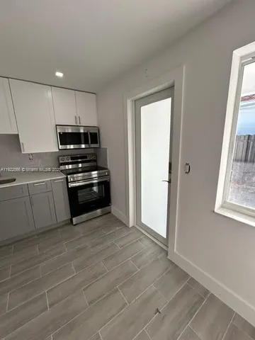a kitchen with a sink a refrigerator and cabinets