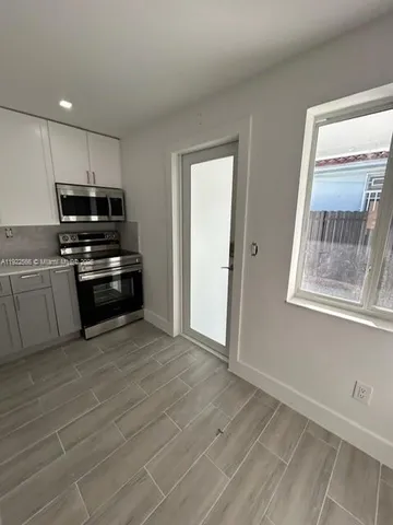 a kitchen with white cabinets and stainless steel appliances