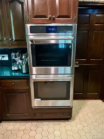 a bed sitting in a bedroom and dressers next to a window