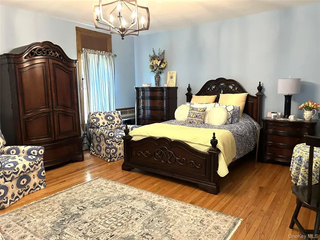 a bedroom with a bed mirror and dresser