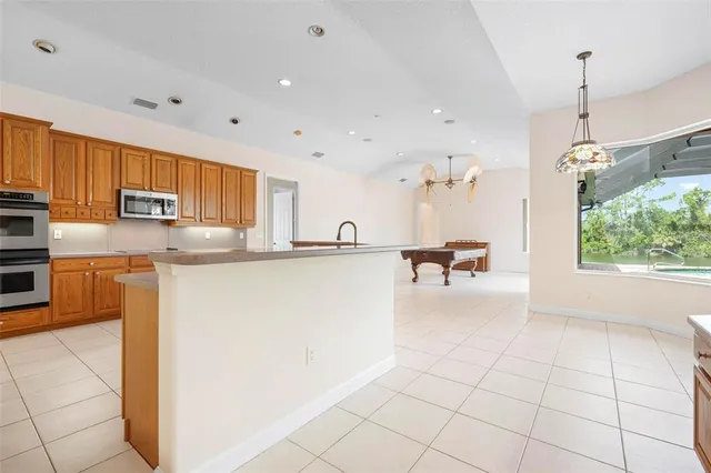 a spacious bedroom with a bed a chandelier and closet