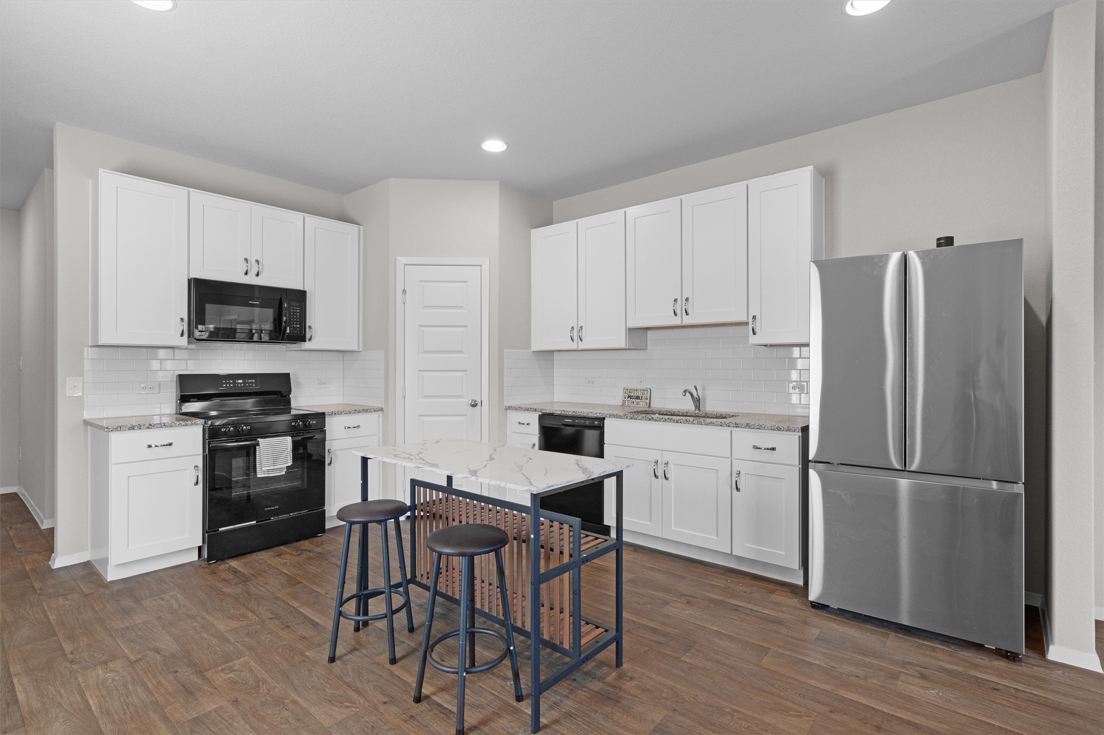 2606 Totley Road Manor, TX 78653 - Photo 5 of 28 a kitchen with white cabinets and stainless steel appliances