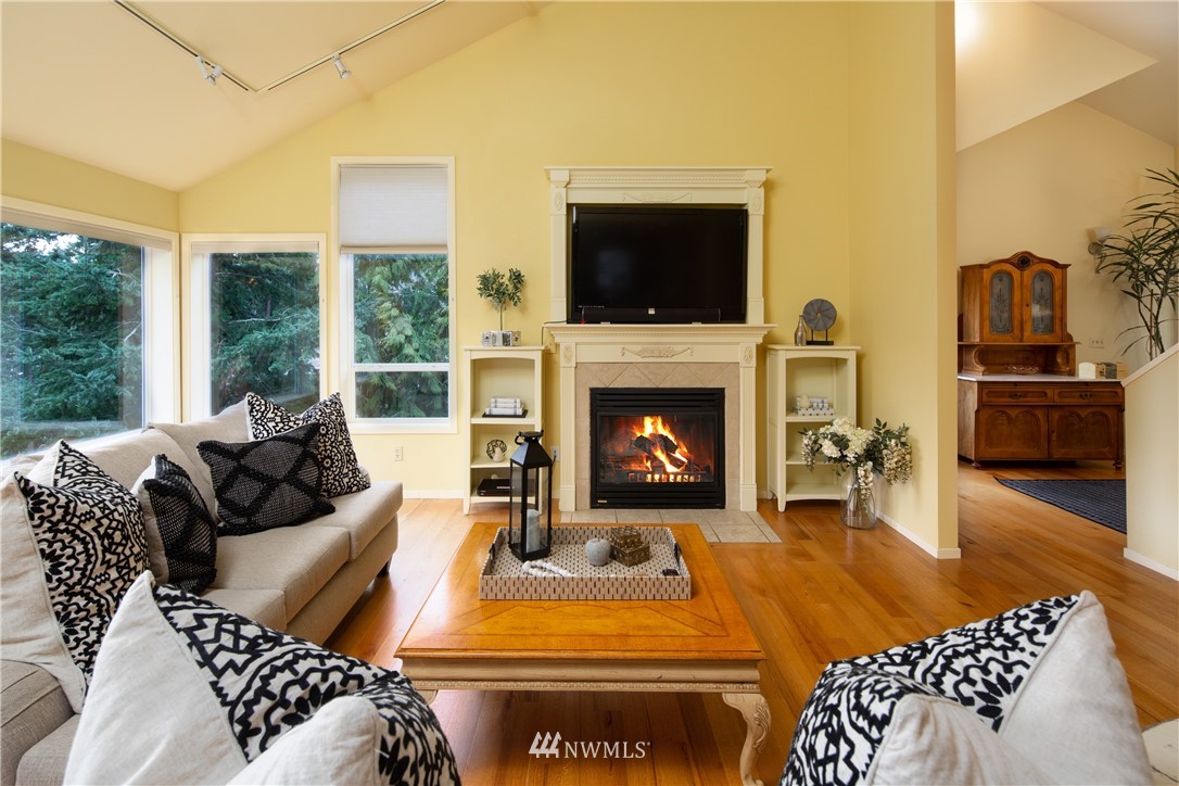 220 Sea Pines Road Bellingham, WA 98229 - Photo 4 of 40 a living room with furniture a flat screen tv and a fireplace