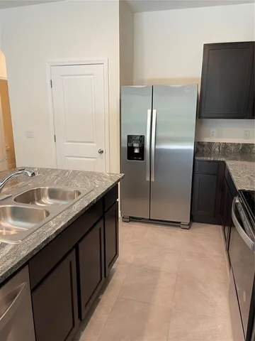 a kitchen with granite countertop a sink and a refrigerator