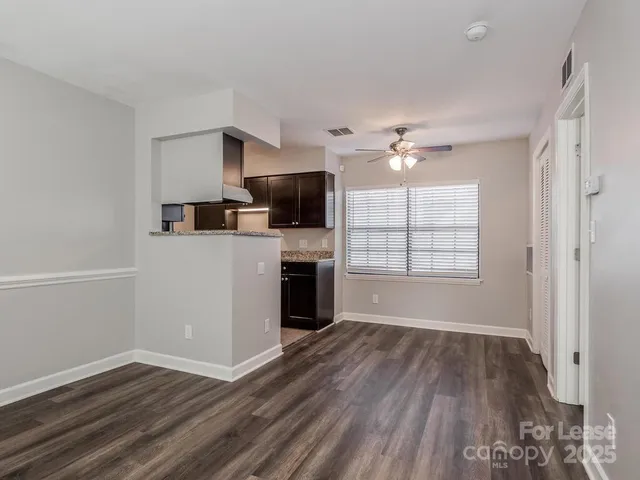 wooden floor in an empty room with a kitchen