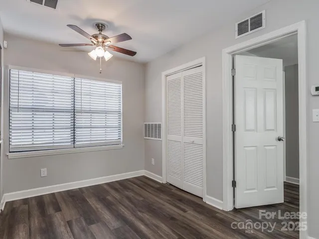 a view of an empty room with chandelier fan and fire place