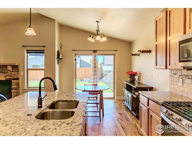 a kitchen with granite countertop a stove a sink and a wooden floors