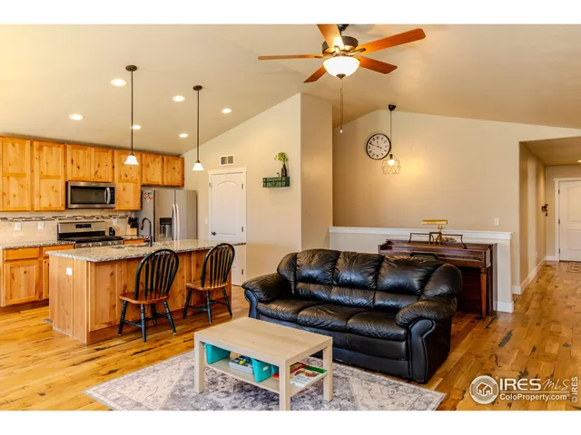 a living room with stainless steel appliances kitchen island granite countertop furniture and a view of kitchen