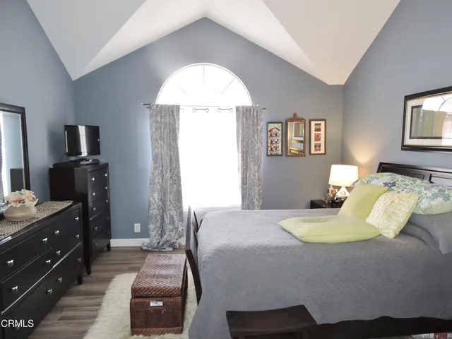 a bedroom with a bed and a mirror on dresser