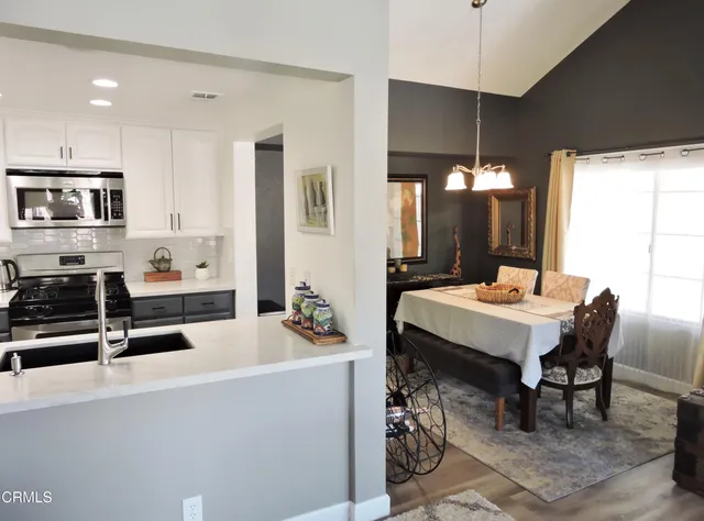 a kitchen with a table chairs microwave and cabinets